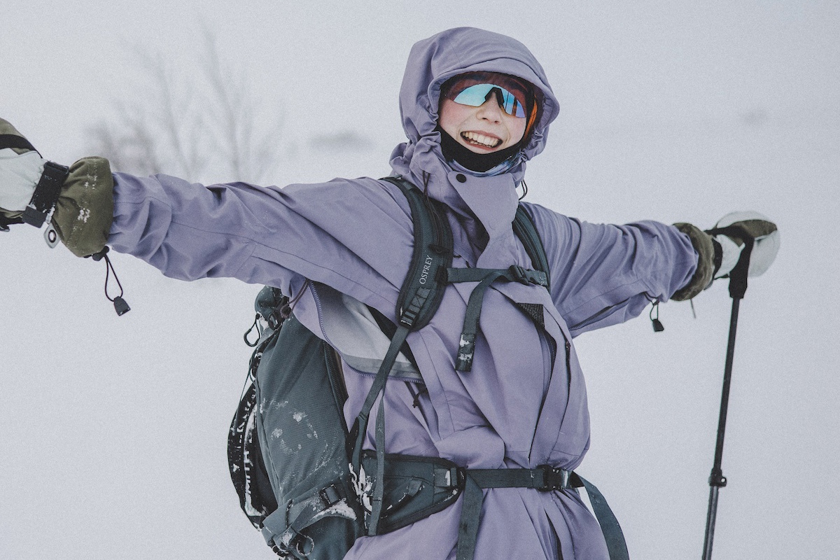 Glad kvinna med solglasögon på fjället.