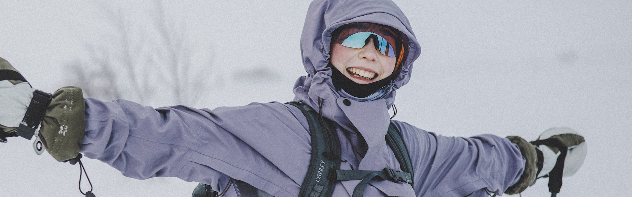 Glad kvinna med solglasögon på fjället.