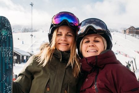 Två kvinnor som håller om varandra i skidbacken i Tänndalen.