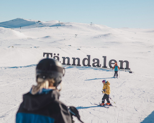Två barn och en skidlärare vid Tänndalsskylten.
