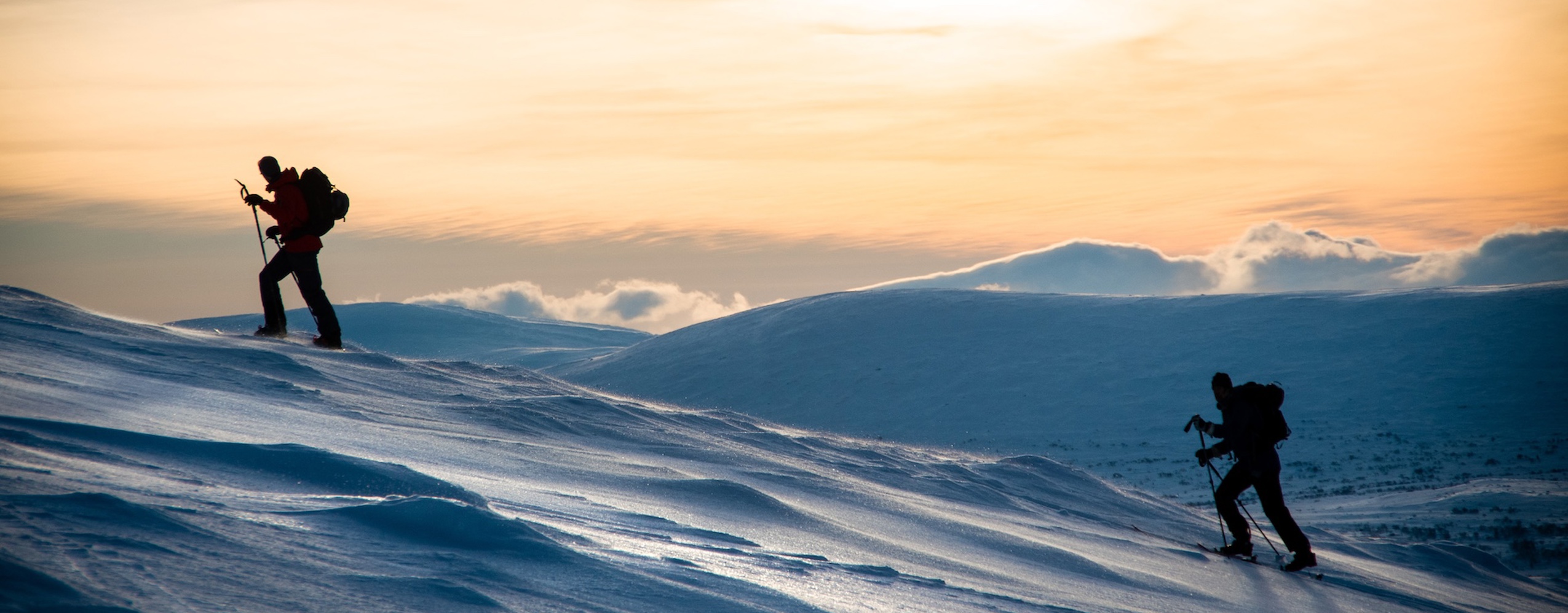 Två skidåkare påväg uppför fjället i Tänndalen vintertid.