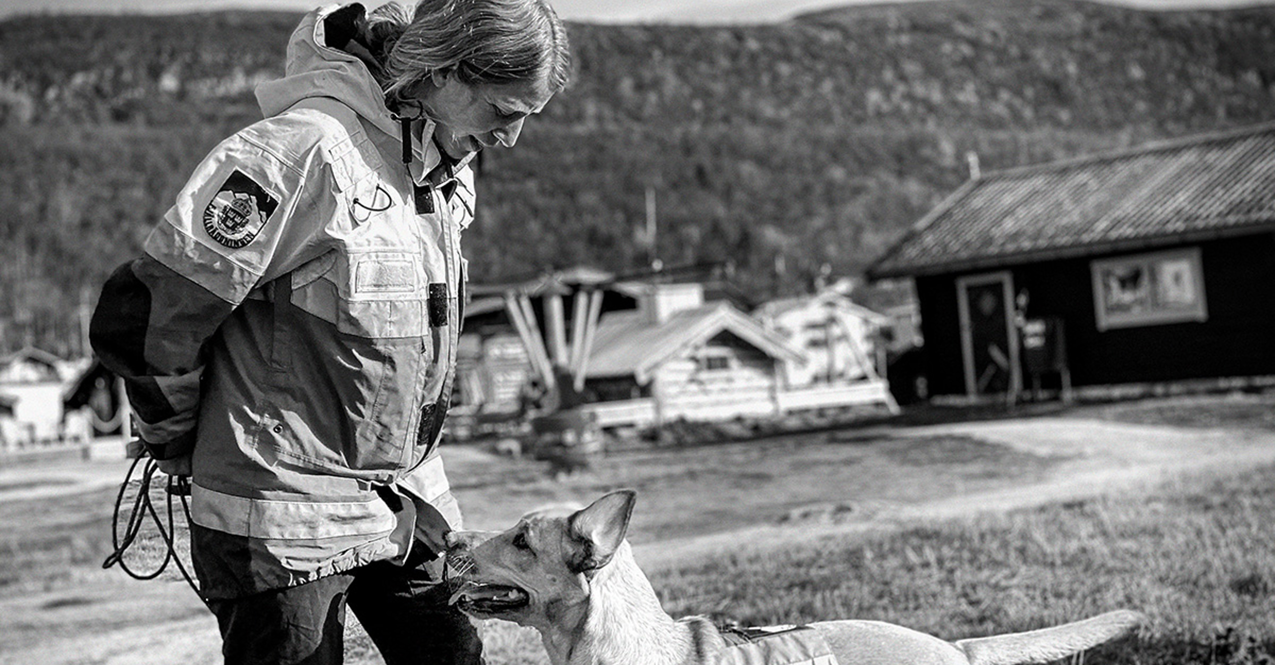 En kvinnlig fjällräddare med en hund.