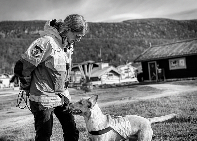En kvinnlig fjällräddare med en hund.
