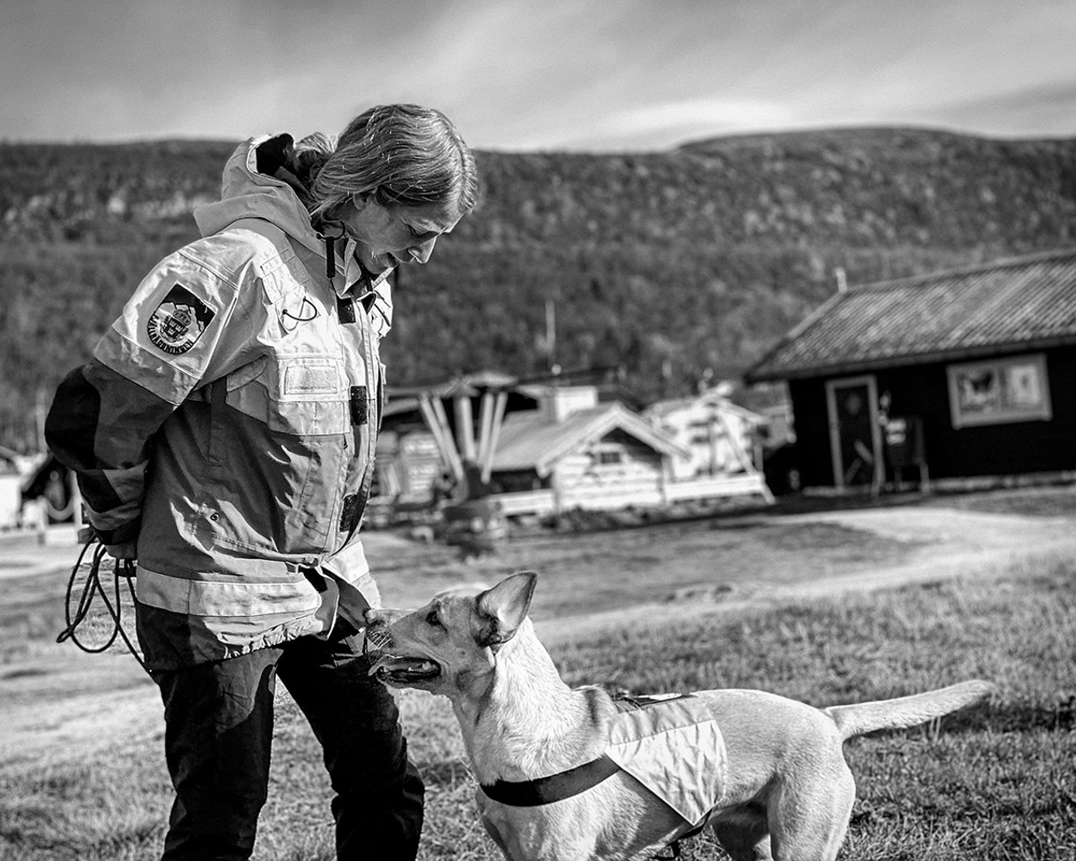 En kvinnlig fjällräddare med en hund.